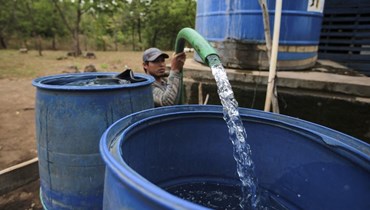 رجل يجمع المياه من بئر عام في ماناغوا (أ ف ب). 