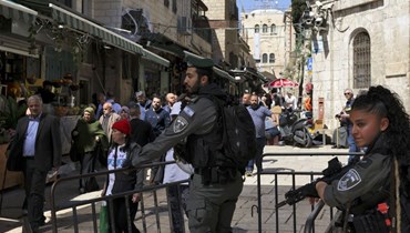 عناصر من قوات الأمن الإسرائيلية يراقبون بينما يتوجه المصلون الفلسطينيون المسلمون إلى المسجد الأقصى لأداء صلاة الجمعة في البلدة القديمة بالقدس (17 آذار 2023، ا ف ب). 