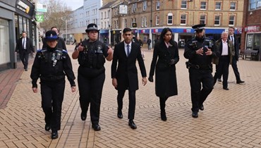 سوناك (في الوسط) ووزيرة الداخلية سويلا برافرمان برفقة رقيبين في الشرطة، خلال زيارة تشيلمسفورد في مقاطعة إسيكس شرق إنكلترا (27 آذار 2023، أ ف ب). 