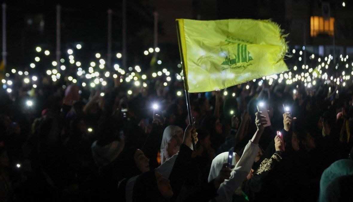 مناصرون لـ"حزب الله" يلوحون بهواتفهم خلال احتفال بمناسبة الذكرى 40 لتأسيس الحزب (أ ف ب).