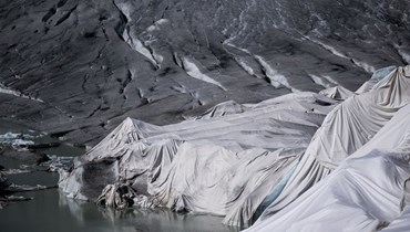  في جبال الألب السويسرية، رغوة عازلة تغطي جزءاً من نهر الرّون الجليدي لمنعه من الذوبان بالقرب من البحيرة الجليدية، تشكّلت من ذوبان الجليد بسبب الاحتباس الحراري (أ ف ب). 