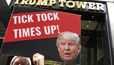 رفع لافتة مندّدة بترامب أمام "برج ترامب" في نيويورك (أ ف ب).