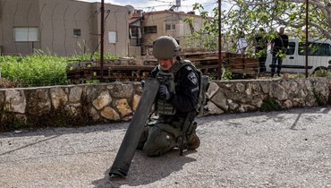 جندي إسرائيلي يتفقّد عبوّة صاروخ أُطلِق من لبنان باتجاه الجليل الغربي (أ ف ب).