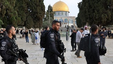زوار يهود يمشون تحت حماية قوات الأمن الإسرائيلية في مجمع المسجد الأقصى في القدس (9 نيسان 2023، ا ف ب). 