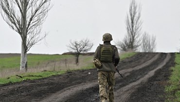 جندي أوكراني يمشي على طريق قرب باخموت بمنطقة دونيتسك (8 نيسان 2023، أ ف ب). 