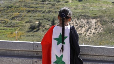فتاة تحمل علم سوريا (أ ف ب).