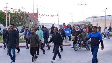  مشيّعون يسيرون باتجاه مركز شرطة في قرية حفوظ في منطقة القيروان وسط تونس بعد جنازة لاعب كرة القدم الذي أضرم النار في نفسه (أ ف ب). 