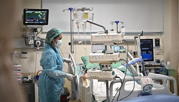 افراد من الطاقم الطبي يهتمون بمريض يعاني مشاكل تنفسية حادة في المعهد المركزي للصدر في تايلاند في بانكوك (21 نيسان 2023، أ ف ب). 