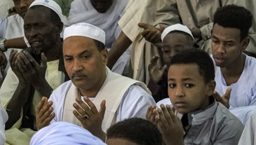 المصلّون في اليوم الأول من عيد الفطر في مسجد الحارة الرابعة غربيّ الخرطوم (أ ف ب).