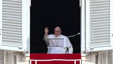 البابا فرنسيس ملوحا بينما يستعد لإلقاء صلاة التبشير الملائكي من نافذة تطل على ساحة القديس بطرس في الفاتيكان (23 نيسان 2023، أ ف ب). 