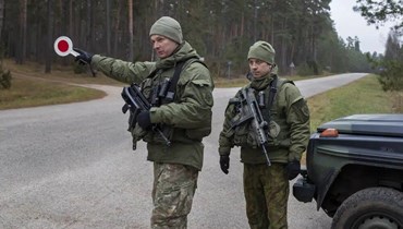 صورة ارشيفية- جنود ليتوانيون يقومون بدورية على طريق قرب الحدود بين ليتوانيا وبيلاروسيا بجوار قرية جاسكونيس بمنطقة دروسكينينكاي على بعد 160 كلم جنوب العاصمة فيلنيوس (13 ت2 2021- أ ب). 