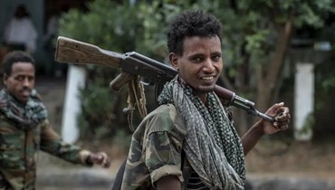 مقاتلون موالون للجبهة الشعبية لتحرير تيغراي يمشون في شارع في بلدة هوزن في منطقة تيغراي شمال إثيوبيا (7 أيار 2021- أ ب).
