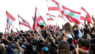 مواطنون يحملون الأعلام اللبنانية (أرشيفية).