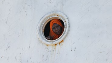  امرأة تقف في عبّارة تنقل حوالي 1900 شخص تم إجلاؤهم من السودان أثناء رسوها في قاعدة الملك فيصل البحرية السعودية في جدّة (أ ف ب). 