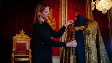 تعديل الوشاح الإمبراطوري ، الذي يشكل جزءاً من ثواب التتويج في غرفة العرش في قصر باكنغهام في لندن (أ ف ب). 