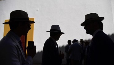 رجال يرتدون قبعات في الظل في إشبيليا (أ ف ب). 