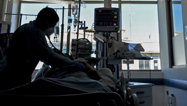 صورة ارشيفية- ممرضة تفحص مريضا مصابا بكوفيد في وحدة العناية المركزة  في مستشفى بكونسيبسيون في تشيلي (12 نيسان 2021، أ ف ب).
