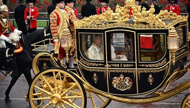 الملك تشارلز الثالث وزوجته كاميلا في عربة ملكيّة خلال حفل التتويج (أ ف ب).