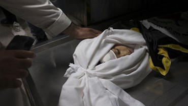 مشيعون تجمعوا حول جثة الفتى الفلسطيني علي عز الدين في مشرحة في غزة قبل جنازته (9 أيار 2023، أ ف ب). 