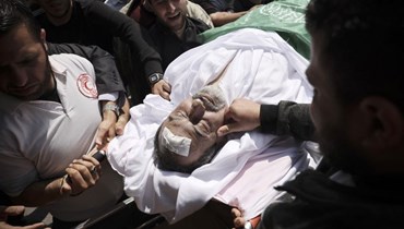 مشيعون في وداع الطبيب جمال خصوان لدى نقل جثته من المشرحة إلى منزله قبل دفنه في مدينة غزة (9 أيار 2023، أ ف ب).