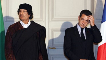 الرئيس الفرنسي نيكولا ساركوزي والزعيم الليبي معمر القذافي خلال التوقيع على 10 مليارات يورو من العقود التجارية بين البلدين، في قصر الإليزيه، باريس (10 ك1 2007 - أ ف ب).