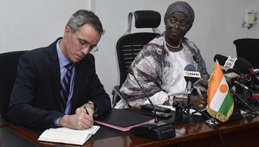 الرئيس التنفيذي لـ"أورانو" نيكولا مايس (الى اليسار) يوقع في نيامي اتفاقية مع وزيرة التعدين النيجيرية هديزا أوسيني بشأن استغلال اليورانيوم (4 أيار 2023، أ ف ب).