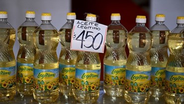 تظهر زجاجات زيت الطهي بعلامة تشير إلى سعرها بالبيزو الأرجنتيني في السوق المركزي في بوينس آيرس (أ ف ب). 