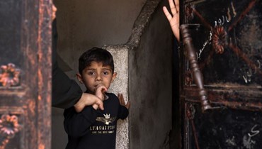  طفل يشاهد جنازة بعد غارة جوية إسرائيلية، في مدينة غزة ، في 12 أيار 2023 (أ ف ب). 