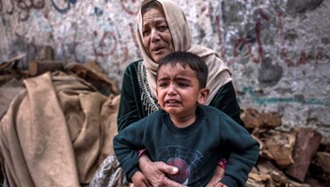 طفل وامرأة يبكيان بعد غارة إسرائيلية على بيت لاهيا شمال قطاع غزة (13 أيار 2023 - أ ف ب).