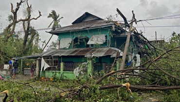 سكان يتفقدون الأضرار في كياوكتاو بولاية راخين في ميانمار بعد مرور الاعصار موكا (14 أيار 2023، أ ف ب). 