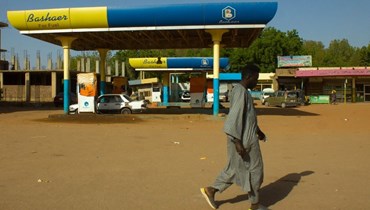 رجل يمشي أمام محطة بنزين مغلقة في السودان (أ ف ب). 