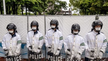 شرطة مكافحة الشغب تقف بالقرب من قبّة القنبلة الذرية ومتنزه ميموريال للسلام في هيروشيما (أ ف ب). 