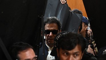 رجال أمن يرافقون خان (في الوسط) خلال مغادرته بعد مثوله أمام المحكمة العليا في لاهور (19 أيار 2023، أ ف ب).