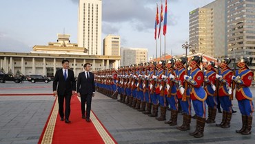 خورلسوخ (إلى اليسار) وماكرون يستعرضان حرس الشرف خلال استقبال في القصر الحكومي في أولان باتور (21 أيار 2023، أ ف ب). 