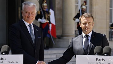 مصافحة بين ماكرون (الى اليمين) ونوسيدا بعد لقائهما في قصر الإليزيه في باريس (24 أيار 2023، أ ف ب).