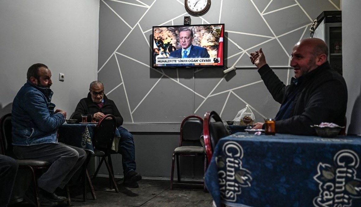 أشخاص يتابعون الأخبار على التلفزيون في مقهى شاي تركي تقليدي في وسط مدينة بايبورت شمال شرق تركيا (23 أيار 2023، أ ف ب). 