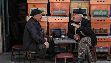 رجلان يجلسان في وسط مدينة بايبورت، شمال شرق تركيا (أ ف ب). 