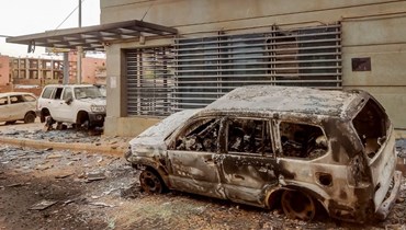 سيارات مدمّرة أمام المقر المحترق للجهاز المركزي للإحصاء السوداني على طريق الستين جنوب الخرطوم (29 أيار 2023، أ ف ب).