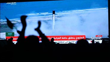   يشاهد الناس شاشة في الرياض بينما تنطلق سفينة الفضاء (كرو دراغون) التابعة لشركة "سبيس إكس" التي تحمل رواد الفضاء (أ ف ب). 