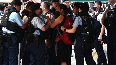  شان تتجادل مع عناصر من الشرطة قبل اقتيادها، في منطقة التسوق كوزواي باي في هونغ كونغ في 4 حزيران 2023 (أ ف ب).  