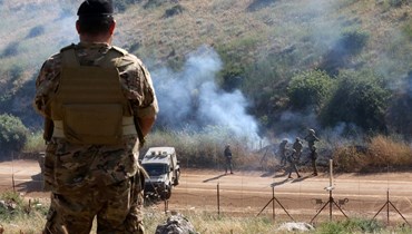 مشهد من سهل الخيام يظهر فيه جندي من الجيش اللبناني يقوم بحراسة الحدود، بينما تقوم القوات الإسرائيلية بدوريات (25 أيار 2023 - أ ف ب).