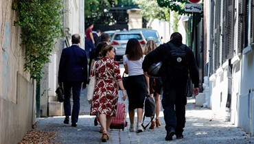 شرطي من قسم الجرائم الالكترونية (الى اليمين) يصل لإجراء تفتيش في منزل ساركوزي في باريس (13 حزيران 2023ـ أ ف ب).