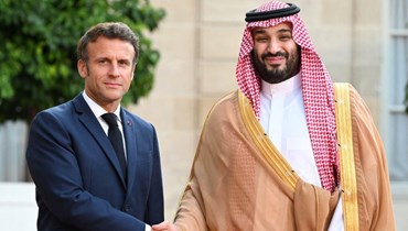 الرئيس الفرنسي إيمانويل ماكرون وولي العهد السعودي في لقاء سابق في باريس (أ ف ب).