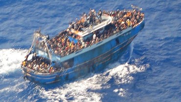 صورة جوّية مأخوذة من مروحيّة إنقاذ، تُظهر مهاجرين على متن سفينة صيد في المياه قبالة ساحل بيلوبونيز، اليونان (13 حزيران 2023 - أ ف ب).
