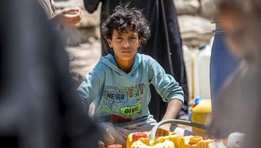 أطفال في اليمن يهتمون بتأمين المياه بدلًا من الذهاب إلى المدرسة (أ ف ب). 