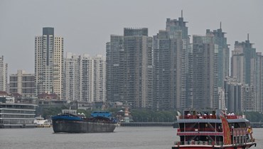 سفن تُبحر على طول نهر هوانغبو في شنغهاي (أ ف ب). 