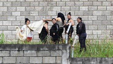 حراس يحرسون نزلاء سجن للنساء في هندوراس بعد مواجهات في داخله (أ ف ب). 