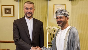 مصافحة بين عبد اللهيان (إلى اليسار) ووزير الخارجية العماني سيد بدر البوسعيدي في مسقط (21 حزيران 2023، ا ف ب). 