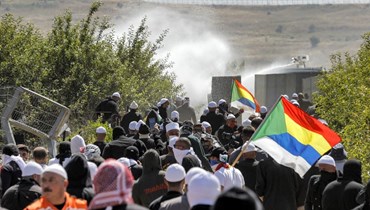  دروز في مواجهة الغاز المسيل للدموع خلال احتجاج على اقامة مزرعة رياح في قريتهم مجدل شمس في مرتفعات الجولان المحتل (21 حزيران 2023، ا ف ب). 