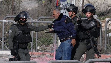 عناصر من القوات الإسرائيلية يوقفون فلسطينيا خلال مواجهات مع متظاهرين في بلدة الرام بالضفة الغربية (27 ك2 2023، أ ف ب).